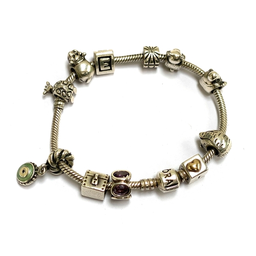 66 - A 925 silver Pandora charm bracelet with an assortment of charms to include hippo, giraffe etc, gros... 