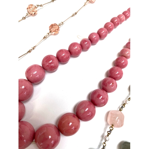23 - A group of eight vintage beaded necklaces to include pink coral style glass beads, moulded lime gree... 