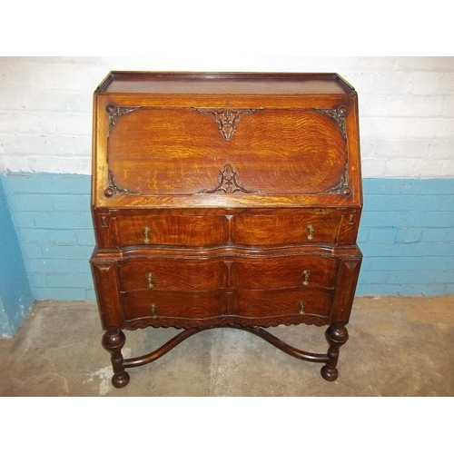 641 - AN ANTIQUE SERPENTINE FRONTED OAK LEATHER INLAID BUREAU