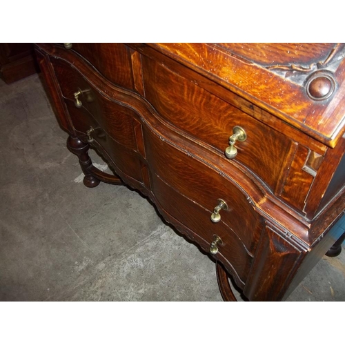 641 - AN ANTIQUE SERPENTINE FRONTED OAK LEATHER INLAID BUREAU