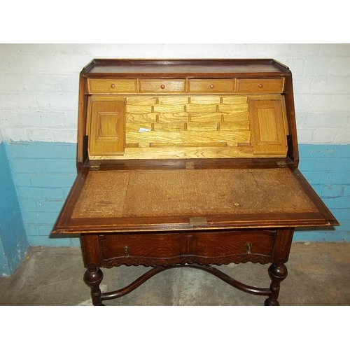 641 - AN ANTIQUE SERPENTINE FRONTED OAK LEATHER INLAID BUREAU