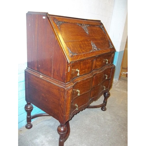 641 - AN ANTIQUE SERPENTINE FRONTED OAK LEATHER INLAID BUREAU