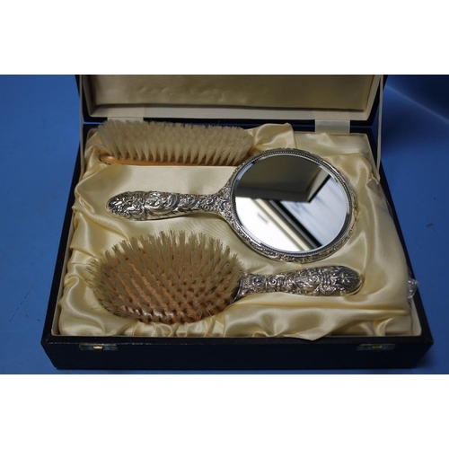 94 - A CASED THREE PIECE HALLMARKED SILVER DRESSING TABLE SET