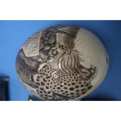 98 - A WHITE METAL TIBETAN PRAYER WHEEL and a carved ostrich egg depicting wild animals, a bakelite viewm... 