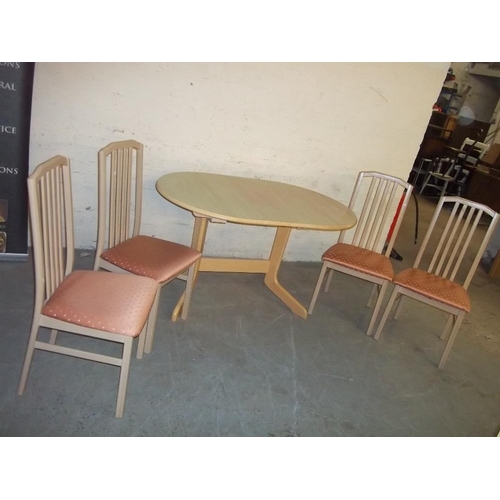 768 - AN EXTENDING BEAUTILITY DINING TABLE AND FOUR CHAIRS