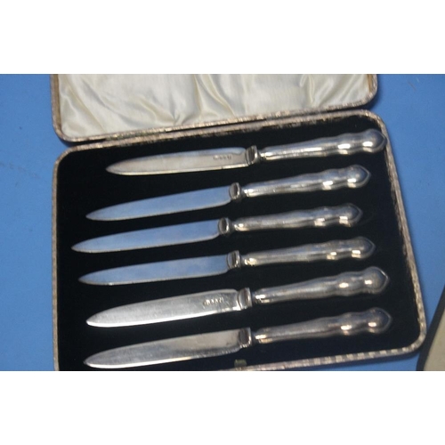 5 - TWO CASED SETS OF SILVER HANDLED KNIVES together with a cased set of white metal coffee bean spoons