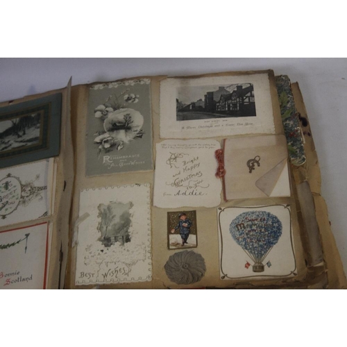 181 - AN EDWARDIAN SCRAP BOOK CONTAINING A COLLECTION OF GREETINGS CARDS, to include various dated example... 