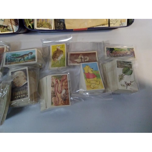 207 - THREE TINS OF ASSORTED TEA AND CIGARETTE CARDS, LOOSE AND IN SLOTS