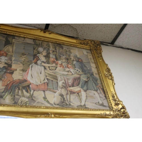 24 - A LARGE GILT FRAMED TAPESTRY OF AN 18TH CENTURY TAVERN SCENE 60.5 CM X 160.5 CM