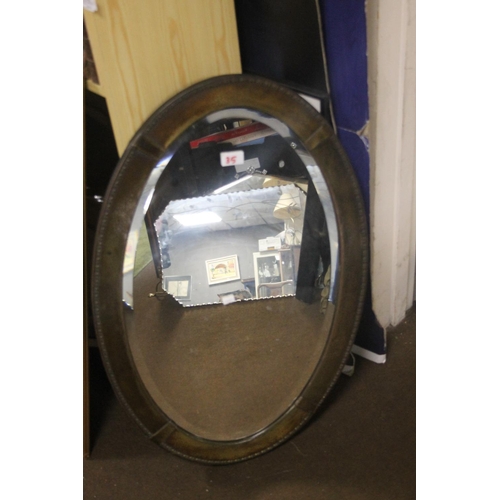 35 - AN OVAL METAL FRAMED MIRROR 80.5 CM X 53 CM