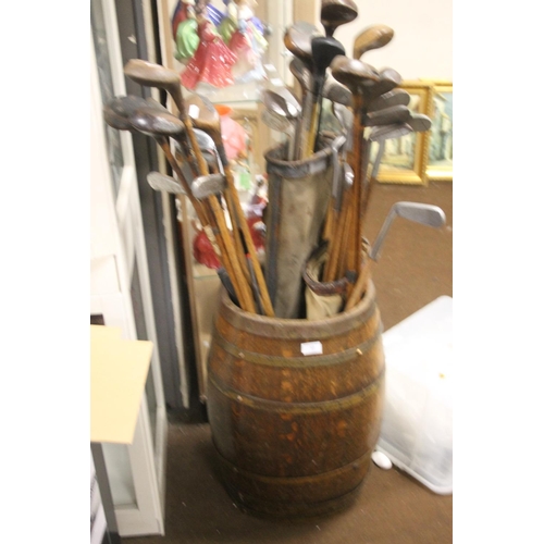 58 - A WOOD BOUND BARREL CONTAINING A QUANTITY OF GOLF CLUBS TO INCLUDE HICKORY EXAMPLES