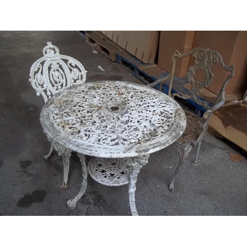 720 - A CAST IRON GARDEN TABLE AND CHAIR WITH A MATCHED EXTRA CHAIR