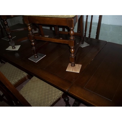 827 - A DARK OAK EXTENDING DINING SET TABLE WITH 8 CHAIRS