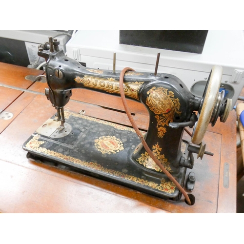 113 - An old Jones treadle operated sewing machine in mahogany cabinet