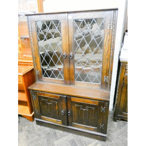 447 - A reproduction oak leaded glazed two door bookcase on a cupboard base with linen fold panels, 3' wid... 