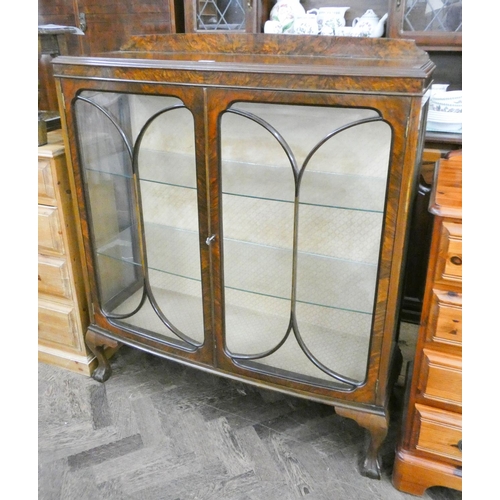 475 - A walnut bow front two door china display cabinet standing on claw and ball feet 3'6 wide