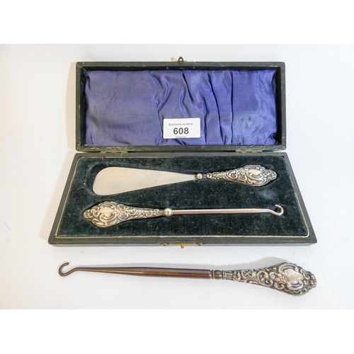 608 - Cased silver handled button hook and shoe horn set together with another button hook