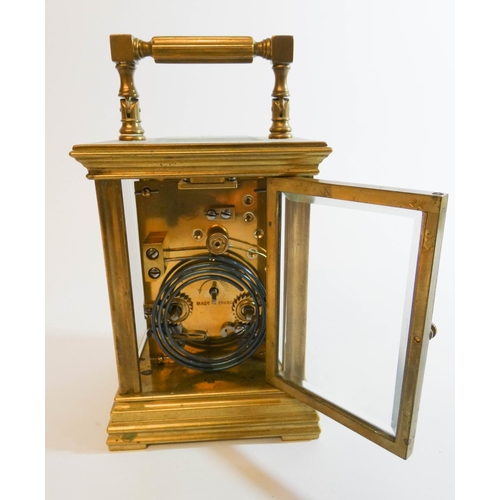 556 - A brass striking carriage clock, white enamel dial signed Reid, height with handle up, 17cm