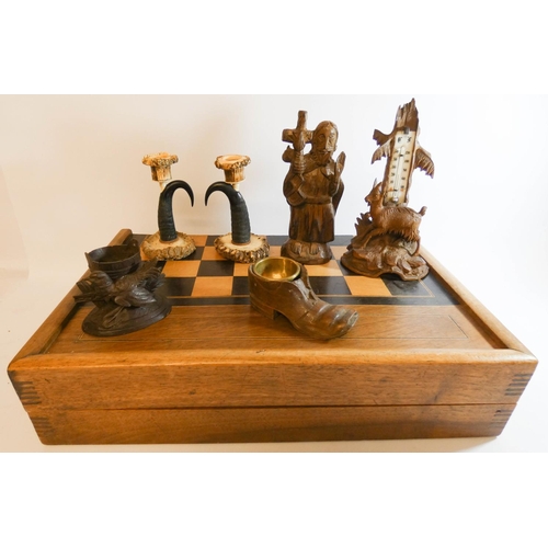 562 - A collection of Black Forest carvings and antler mounted candle sticks together with a backgammon bo... 