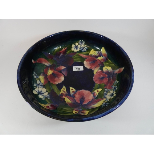 485 - A William Moorcroft large shallow bowl decorated with Iris on a blue ground, 32cms across