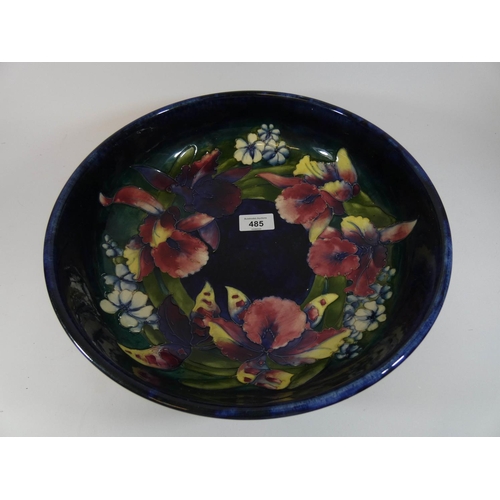 485 - A William Moorcroft large shallow bowl decorated with Iris on a blue ground, 32cms across