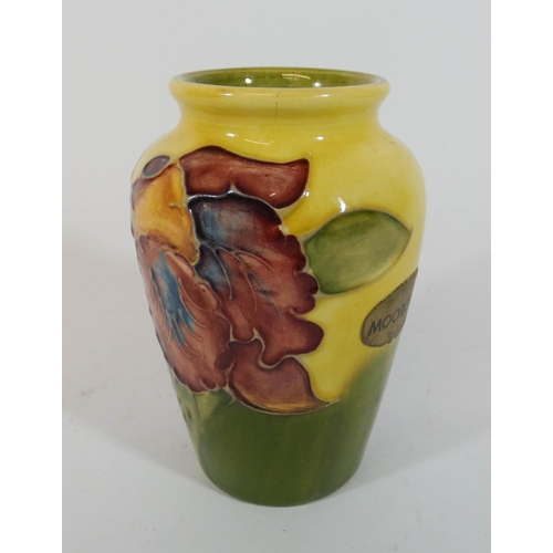 493 - A small Moorcroft vase decorated with an Iris on a green and yellow ground, height 10cms