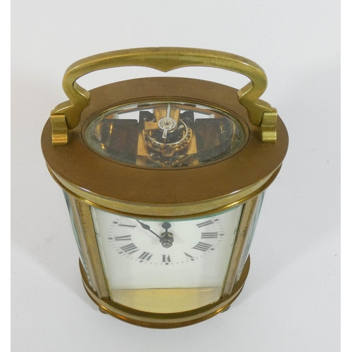 499 - A French gilt brass oval carriage clock with key, height with the handle up 15cms