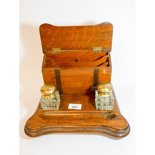 483 - A 1920's oak inkstand with two cut glass and brass mounted inkwells