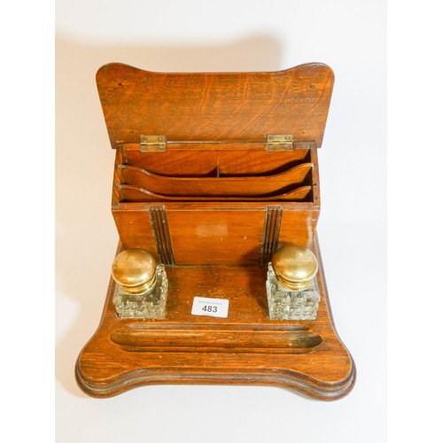 483 - A 1920's oak inkstand with two cut glass and brass mounted inkwells