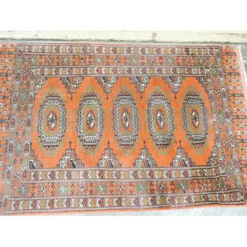 293 - A red patterned Bokhara design wool pile rug, approximately 4' x 2'6