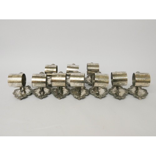 535 - Ten silver plate napkin ring holders supported by cherubs on fancy bases