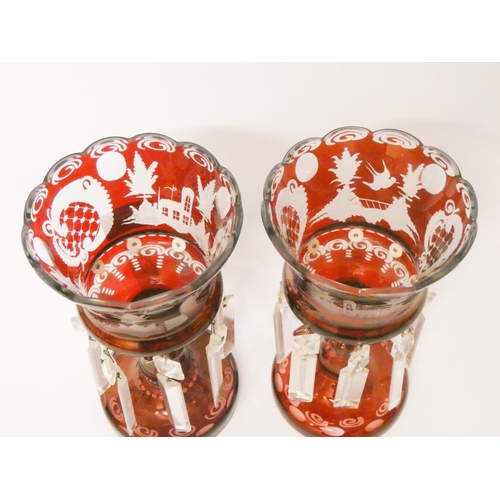 525 - A pair of Bohemian ruby glass lustre candlesticks, approximately 9