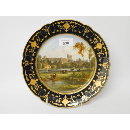 530 - A Sevres style blue and gilt bordered porcelain plate decorated with landscape castle scene,  9 1/4