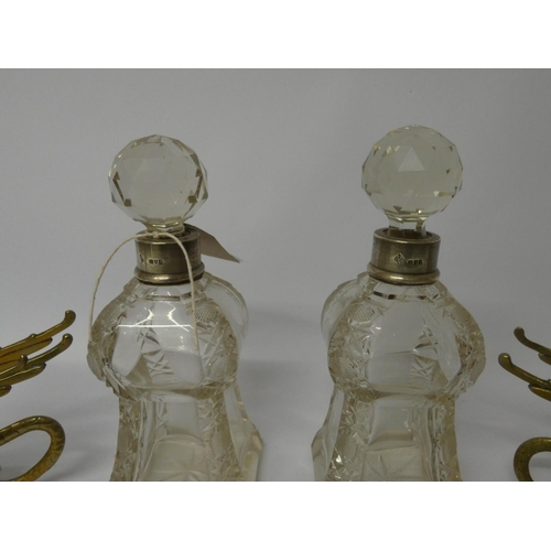 542 - A pair of shaped and cut glass silver mounted small decanters and a pair of brass Griffin candlestic... 