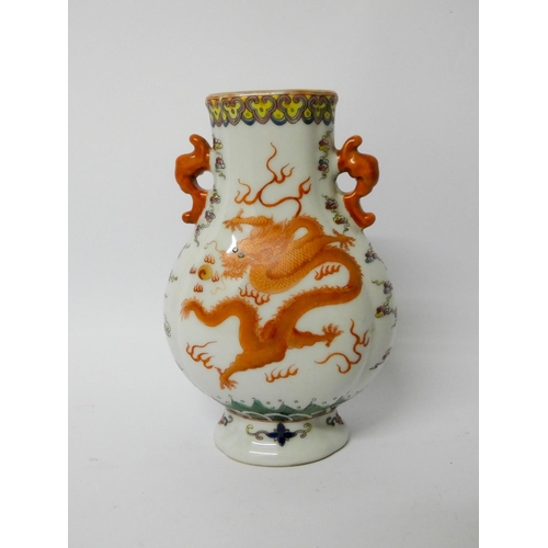 549 - A Famille rose dragon decorated Chinese two handled vase with six character mark to the base