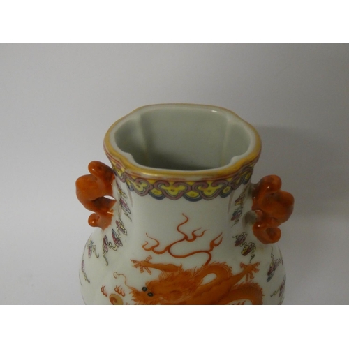 549 - A Famille rose dragon decorated Chinese two handled vase with six character mark to the base