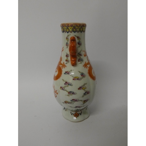 549 - A Famille rose dragon decorated Chinese two handled vase with six character mark to the base