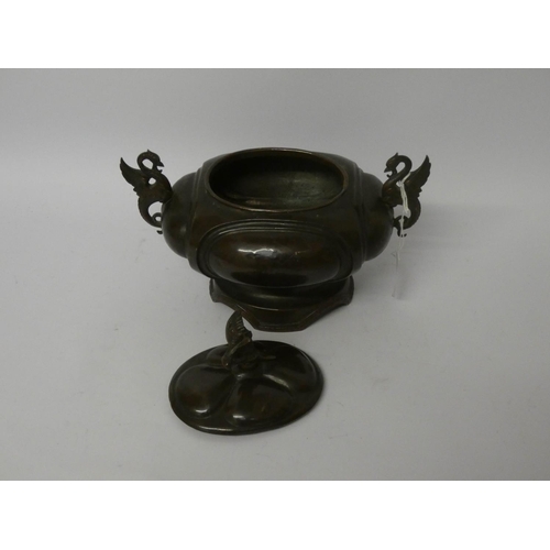 561 - A Japanese bronze oval bowl with cover with winged dragon handles, overall width 8 1/2