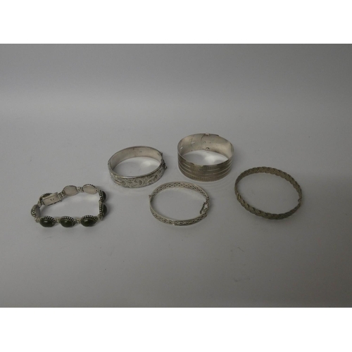 654 - Three marked silver ladies hinged bangles, a silver and stone set bracelet and a woven plaited desig... 