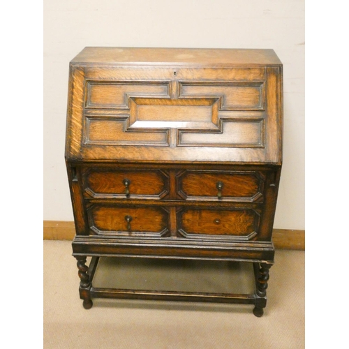 741 - A Jacobean style oak bureau with two drawers under standing on barley twist legs, 2'6 wide