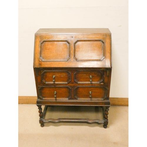 743 - A Jacobean style oak bureau with two long drawers under standing on barley twist legs, 2'6 wide