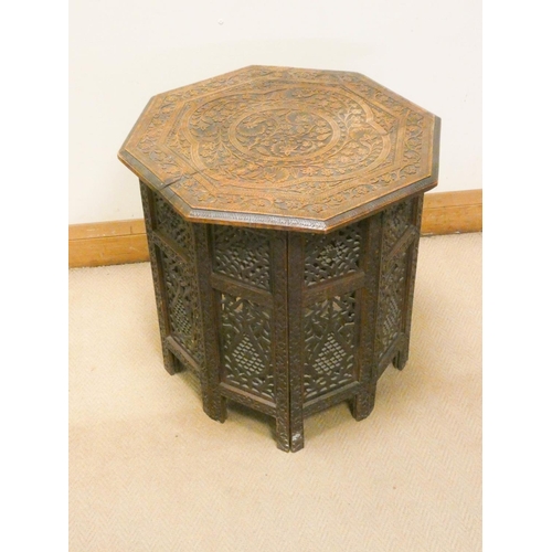 828 - An eastern floral carved octagonal table with folding base