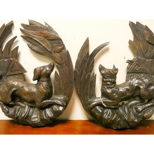 850 - A pair of carved wood black forest wall plaques of dogs