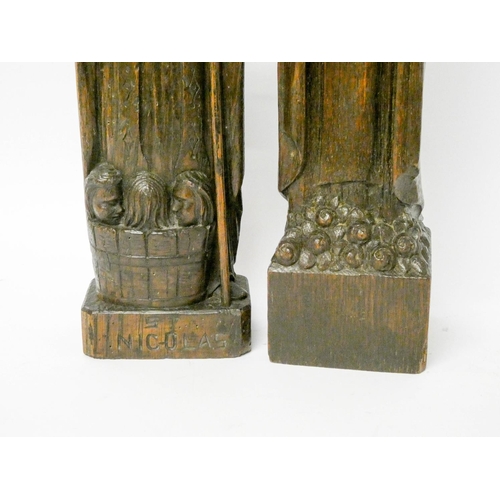 887 - A Black Forest style carved wooden figure of St Nicholas and another of lady saint with roses, the l... 