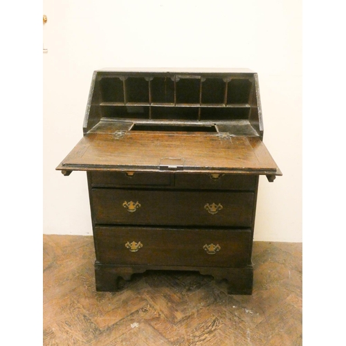 897 - A small 18th century oak bureau fitted with pigeon hole and well with two long and two short drawers... 