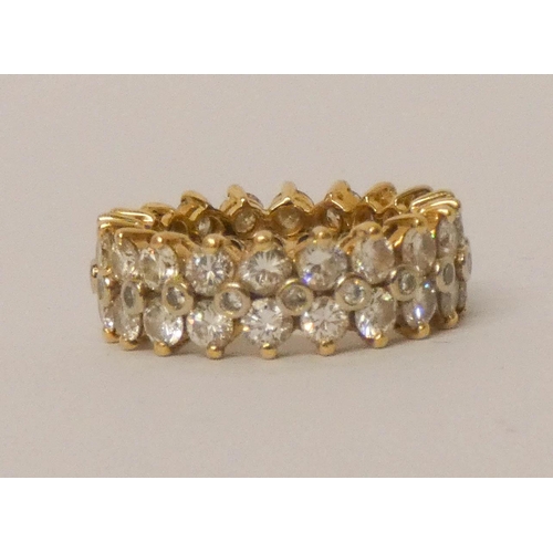 688 - A fully diamond set substantial eternity ring, set with three rows of brilliant cut diamonds, all se... 