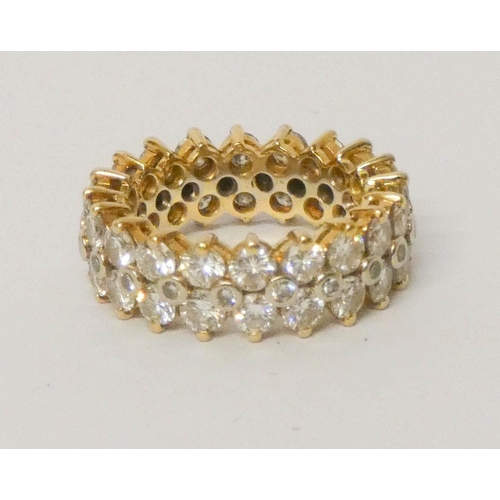 688 - A fully diamond set substantial eternity ring, set with three rows of brilliant cut diamonds, all se... 