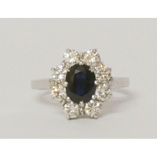 693 - A sapphire and diamond cluster ring, large oval sapphire surrounded by brilliant cut diamonds, on pl... 