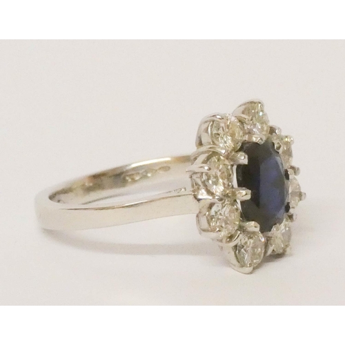 693 - A sapphire and diamond cluster ring, large oval sapphire surrounded by brilliant cut diamonds, on pl... 