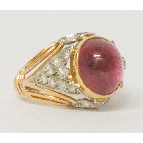 697 - A statement dress ring, set with a large oval cabochon on diamond shoulders in 18ct yellow gold. Rin... 